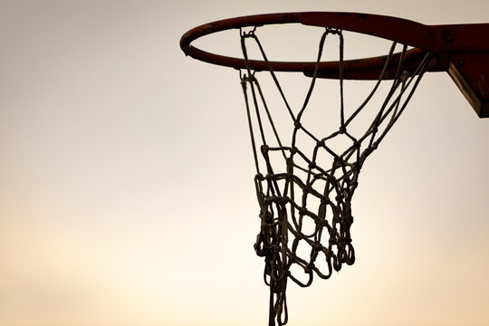 Silueta de una canasta de baloncesto (basket, basketball) durante un atardecer de verano (outdoor al aire libre)
