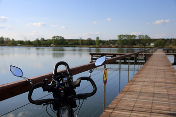 Kierownica roweru turystycznego, trekkingowego na kąpielisku wodnym w Siołkowicach Nowych. - obrazy, fototapety, plakaty