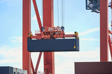 Terminal crane is moving a container in the industrial cargo por Hamburgt, concept for transport,...