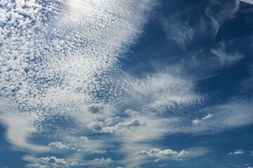 altocumulus and cirrus clouds on the blue sky, background for nature, weather and climate themes,...