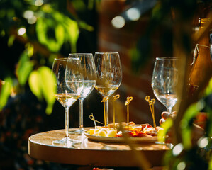 wine that is poured into glasses in the rays of the setting sun