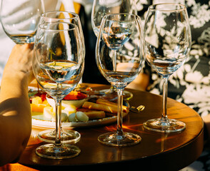 wine that is poured into glasses in the rays of the setting sun