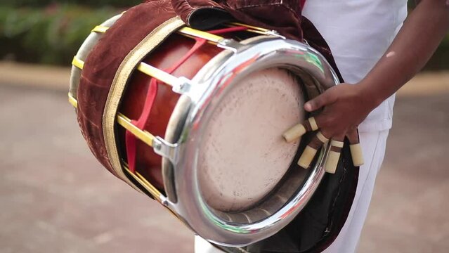 A shot of a musician playing the dholak instrument at a function in New Delhi, India