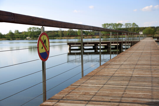 Znak zakazu kąpieli na molo, deptaku na kąpielisku wodnym w Siołkowicach Nowych.