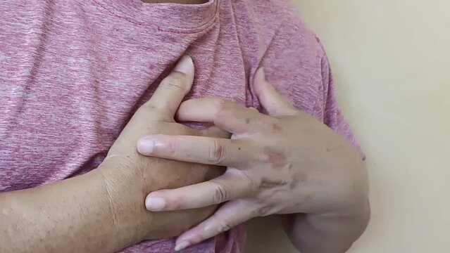 A man with heart disease is squeezeing a massage on his left chest.