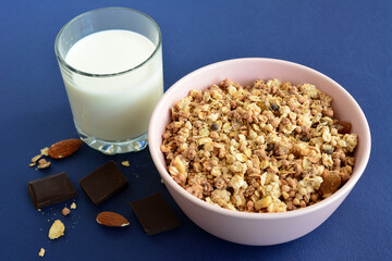 muesli with chocolate and almond in pink bowl, close-up