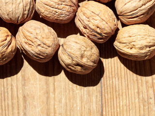 Walnuts on a wooden table in the bright sun.