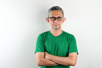 Obraz premium Asian man wearing tshirt over isolated white background happy face smiling with crossed arms looking at the camera. Positive person. 