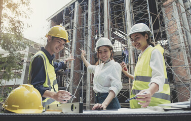 A diverse team of experts are planning on the construction site. Real estate project with civil...