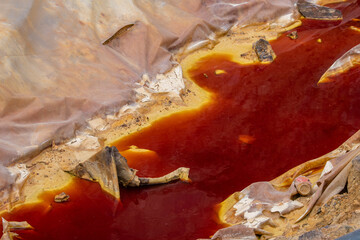 Red polluted toxic water in copper mine. Mining of ores of various metals. Reddish water in the...
