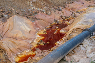 Red polluted toxic water in copper mine. Mining of ores of various metals. Reddish water in the...