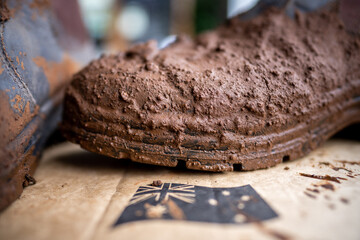 Muddy boots on a farm in Australia. Dirty shoes covered in dirt and foot and mouth disease. Bio security to stop contaminated footwear and clothes spreading disease in cows