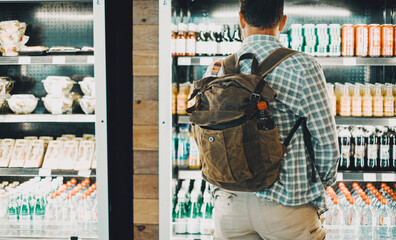 Traveler backpack man in front of a drinks and food window store. People and travel lifestyle...