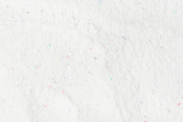 Laundry detergent for washing machines texture background. Washing powder. White wash powder with with colored granules