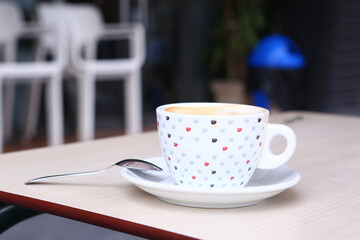 cup of coffee with cream and coffee beans close up photo