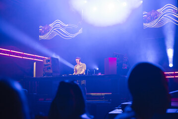 Dj playing techno music on the live night concert in summer