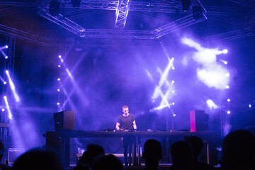 Fototapeta na wymiar Dj playing techno music on the live night concert in summer