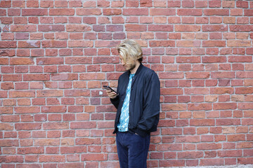 Fototapeta na wymiar Lifestyle portrait of young man using a smartphone outdoors.