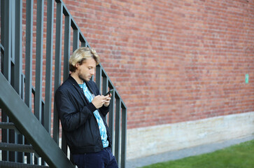 Lifestyle portrait of young man using a smartphone outdoors.