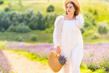 Fashionable young woman walking through rural lavender fields
