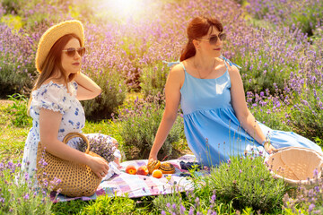 Two trendy women friends having a summer picnic outdoors