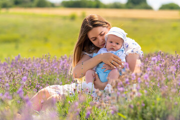 Outdoor portrait of a young baby boy with his mother