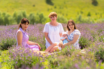 Three women sitting amongst lavender with a small baby boy
