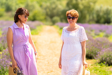 Two lady friends posing standing in a field of lavender