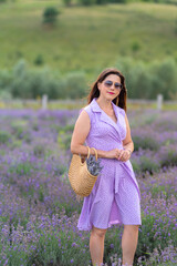 Stylish brunette woman posing in a field of purple lavender