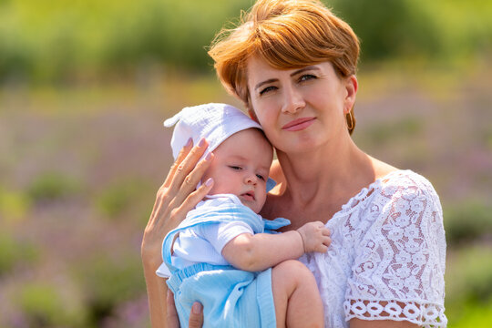 Attractive grandmither holding her little baby grandson