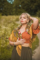 Ethnic gypsy woman posing in boho style clothes at nature. Outdoor fashion. Concept of ethnos style 