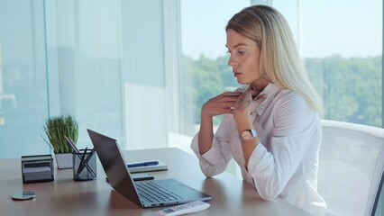 Businesswoman employee feels suffocated working on laptop turn on air conditioner using remote control, cooling system or humidifier. Concentrated woman sets a comfortable temperature Hot summer time.