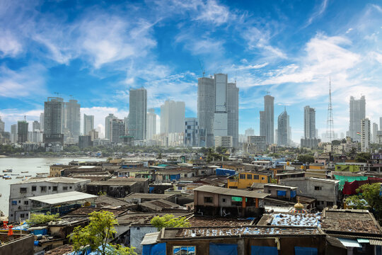 Views of slums on the shores of Mumbai, India against the backdrop of skyscrapers under construction.