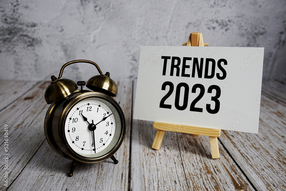 Poster trends 2023 text message and alarm clock on wooden background