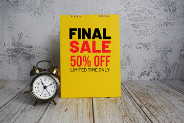 Final Sale 50% off text message and alarm clock on wooden background