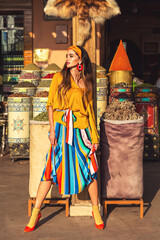 A beautiful girl stands near spices in the market of the city of Essaouira in Morocco