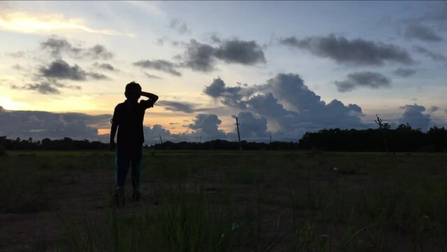 silhouette of a small boy giving salute to Indian Tri colour national Flag