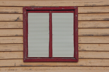 old shuttered window on weatherboard wall