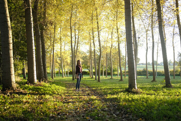 Teenage girl standing on a footpath in a forest glade, France