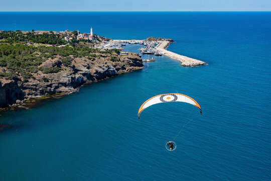 Aerial view of paramotor approching the Rumelian fishing port and the Rumelian Lighthouse at the Black Sea entrance to the Bosphorus, Istanbul, Turkey.