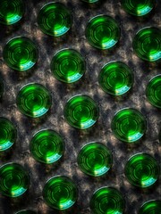 A creative pattern from the top view of shots with absinthe on a black concrete background. Abstract background of glasses with a green bitter drink from wormwood.
