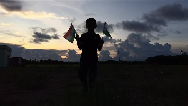 
little Boy holding tri colour national Indian flag in the nature & waving flag in the air. Independence Day - Holiday and Republic Day