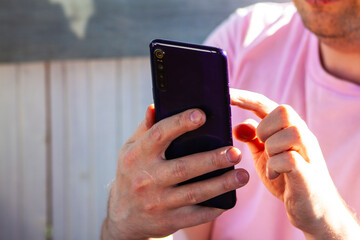 A man taps on a smartphone screen. View purchases online