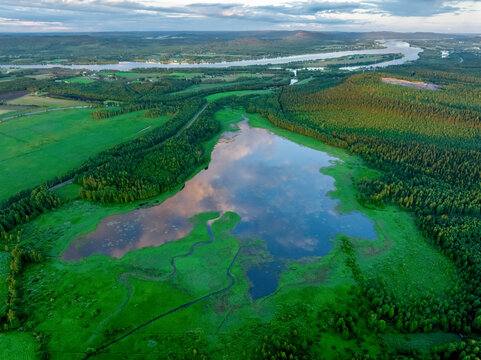 Aerial view of lake reflecting clouds during golden hour in Overtornea, Sweden.