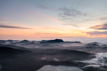 Aerial view of fog over the mountain peaks at sunset in Iceland.