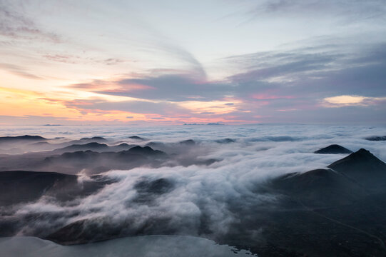 Aerial view of fog over the mountain peaks at sunset in Iceland.