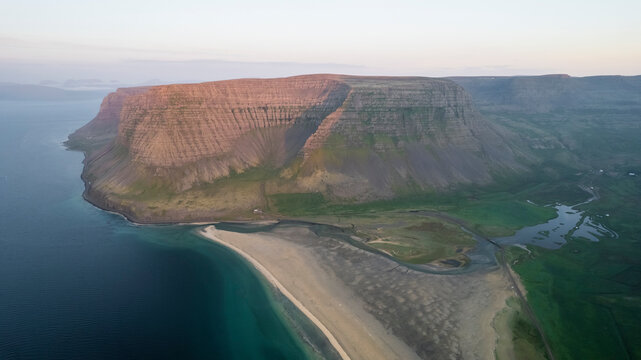 Aerial view of the beautiful coastline with high cliffs and mountain at sunset, Westfjords.