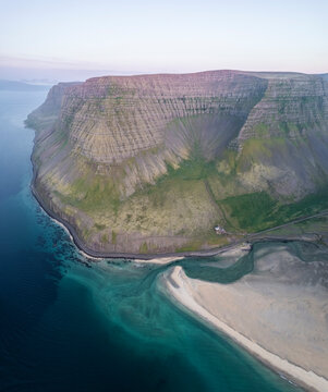 Aerial view of the beautiful coastline with high cliffs and mountain at sunset, Westfjords.