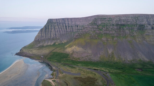 Aerial view of the beautiful coastline with high cliffs and mountain at sunset, Westfjords.