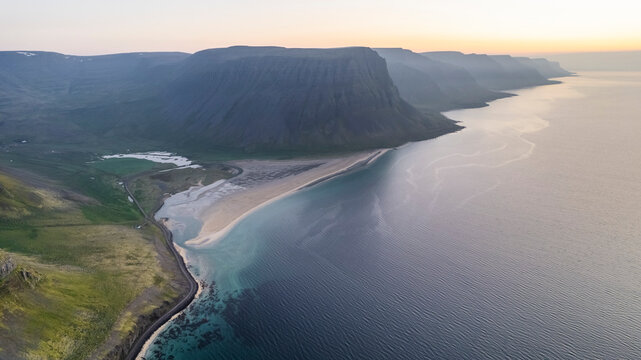 Aerial view of the beautiful coastline with high cliffs and mountain at sunset, Westfjords.